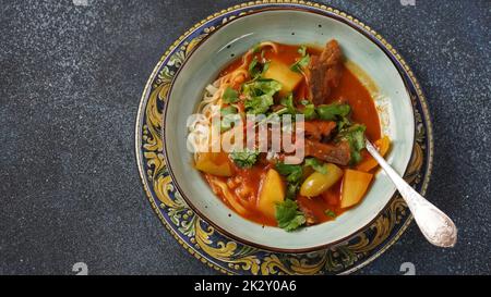 Traditional asian noodle soup with vegetables, potatoes and meat, - lagman. Oriental, uzbek style cuisine Stock Photo