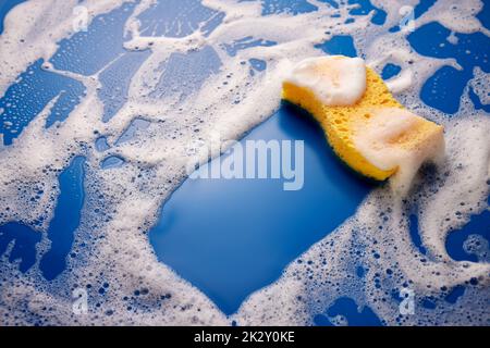 Sponge on soapy blue table Stock Photo