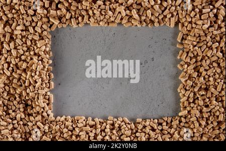 Natural frame made of fuel pellets on gray surface Stock Photo