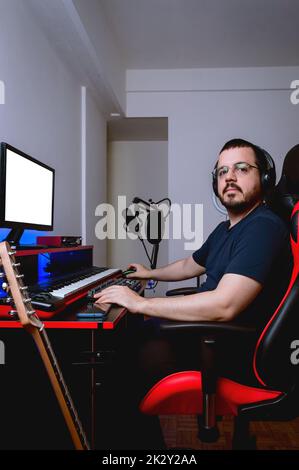young latin caucasian man with glasses and beard, sitting in his home study looking at the camera indignant because the internet is very slow Stock Photo