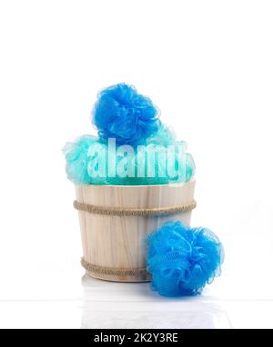 Blue color sponges into a wood basket against bathroom ambiance Stock Photo