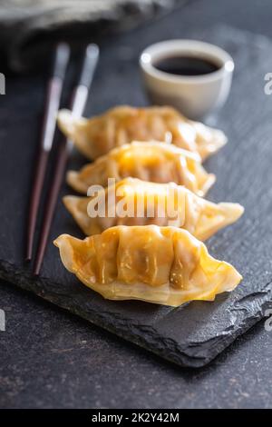 Chinese dumplings abd soy sauce on cutting board. Stock Photo