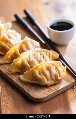 Chinese dumplings abd soy sauce on cutting board. Stock Photo