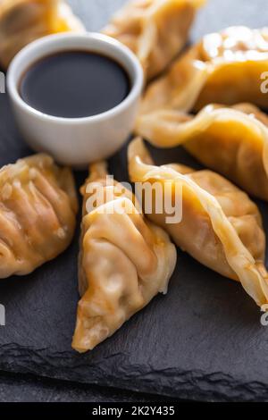 Chinese dumplings abd soy sauce on cutting board. Stock Photo