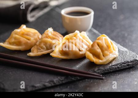 Chinese dumplings abd soy sauce on cutting board. Stock Photo