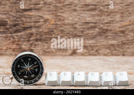 Compass and computer keyboard keys arranged to spell SEARCH word on the wooden background Stock Photo