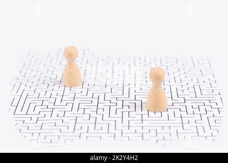 Men stand in the middle of a labyrinth, searching for a solution to exit, finding a strategy, challenge and problem solving concept Stock Photo