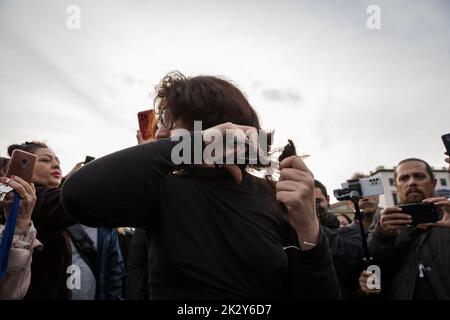 Berlin, Germany. 23rd Sep, 2022. Protest in Berlin at Pariser Platz on September 23, 2022, over the death of Iranian Mahsa Amini. Many women cut their hair in Berlin as a sign of protest and solidarity. The protesters in Berlin were protesting against the regime of President Ebrahim Raisi and the strict dress codes that especially women in Iran suffer from. Amini was an Iranian woman of Kurdish origin. Mahsa Amini was arrested by the Iranian morality police for allegedly not wearing the hij?b correctly in public. Amini fell into a coma and died three days after her arrest in the intensive care Stock Photo