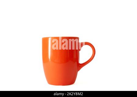 Shiny ceramic orange color tea cup or mug isolated on white background. Stock Photo