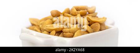 Panorama of roasted salted peanuts in a white square bowl.  Isolated against a white background. Stock Photo