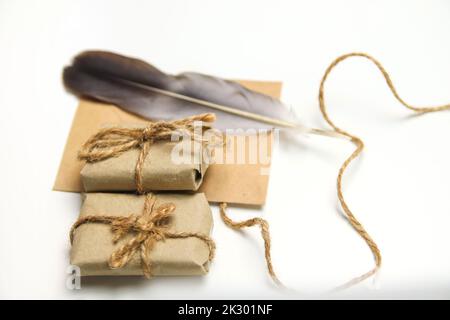 Defocus craft eco rope and envelope, feather pen on white background. Christmas holiday concept. Letter to Santa Claus. Wish list. Old quill pen. Retr Stock Photo