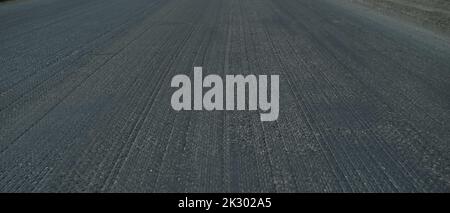 Old asphalt. Budget repair of the road. Broken asphalt in the forest. banner Stock Photo