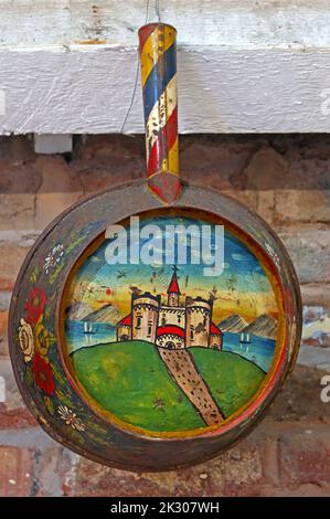 Traditional hand-painted castle on canal barge ware, pan, hanging up, on the side of an English waterway Stock Photo