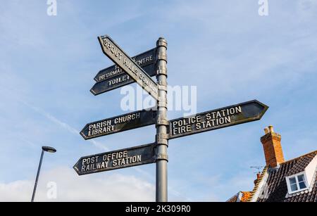 Signpost pointing to local amenities and places of interest in the centre of Holt, a small historic Georgian market town in north Norfolk, England Stock Photo
