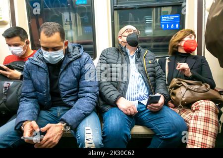 People commuters passengers in PPE face masks inside Madrid metro subway train Stock Photo