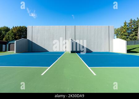 Example of an outside American Handball courts with concrete wall, located at a park or school. Stock Photo