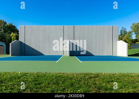 Example of an outside American Handball courts with concrete wall, located at a park or school. Stock Photo