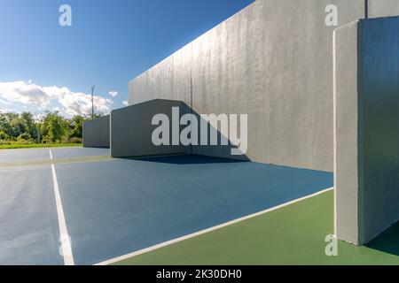 Example of an outside American Handball courts with concrete wall, located at a park or school. Stock Photo