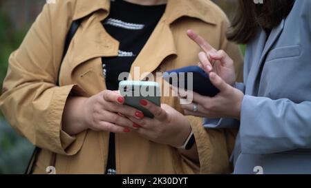 Women's hands hold smartphones. Women communicate and use phones Stock Photo