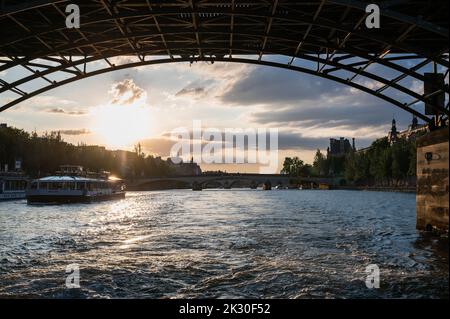 Paris, France - August 26 2022: Sunset at Bridge Pont des Arts, pedestrian bridge that has international reputation as the bridge of romance. Stock Photo