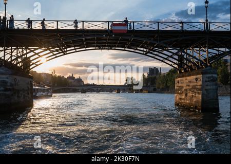 Paris, France - August 26 2022: Sunset at Bridge Pont des Arts, pedestrian bridge that has international reputation as the bridge of romance. Stock Photo