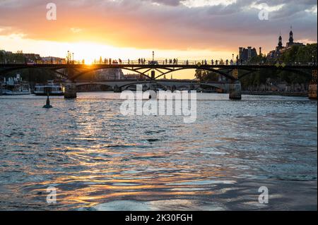 Paris, France - August 26 2022: Sunset at Bridge Pont des Arts, pedestrian bridge that has international reputation as the bridge of romance. Stock Photo