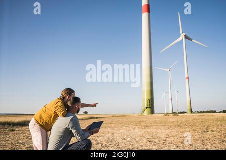 Family using digital tablet in wind park Stock Photo