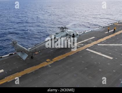 220921-N-TT639-2013 PHILIPPINE SEA (Sept. 21, 2022) – An MH-60S Sea Hawk helicopter assigned to Helicopter Sea Combat Squadron (HSC) 23 takes off from the flight deck aboard amphibious assault carrier USS Tripoli (LHA 7) Sept. 21, 2022. Tripoli is operating in the U.S. 7th Fleet area of operations to enhance interoperability with allies and partners and serve as a ready response force to defend peace and maintain stability in the Indo-Pacific region.  (U.S. Navy photo by Mass Communication Specialist 3rd Class Christopher Sypert) Stock Photo