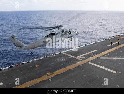 220921-N-TT639-2049 PHILIPPINE SEA (Sept. 21, 2022) – An MH-60S Sea Hawk helicopter assigned to Helicopter Sea Combat Squadron (HSC) 23 takes off from the flight deck aboard amphibious assault carrier USS Tripoli (LHA 7) Sept. 21, 2022. Tripoli is operating in the U.S. 7th Fleet area of operations to enhance interoperability with allies and partners and serve as a ready response force to defend peace and maintain stability in the Indo-Pacific region.  (U.S. Navy photo by Mass Communication Specialist 3rd Class Christopher Sypert) Stock Photo