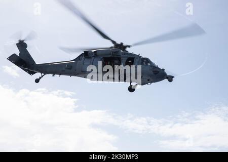 220920-N-XN177-1034 PHILIPPINE SEA (Sept. 20, 2022) – An MH-60S Sea Hawk helicopter assigned to Helicopter Sea Combat Squadron (HSC) 23 flies over amphibious assault carrier USS Tripoli (LHA 7) Sept. 20, 2022. Tripoli is operating in the U.S. 7th Fleet area of operations to enhance interoperability with allies and partners and serve as a ready response force to defend peace and maintain stability in the Indo-Pacific region.  (U.S. Navy photo by Mass Communication Specialist 1st Class Peter Burghart) Stock Photo