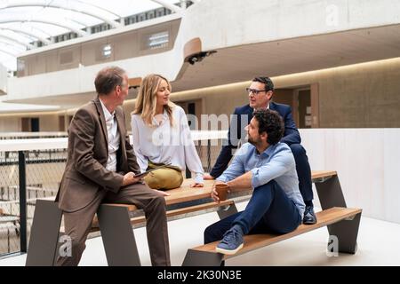 Multiracial business colleagues planning strategy sitting on bench Stock Photo