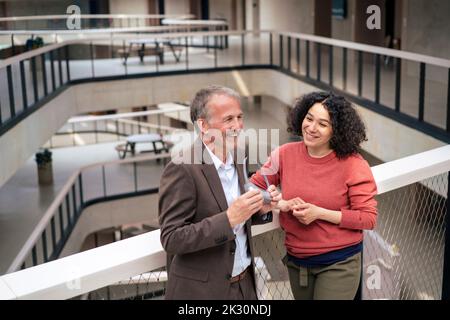 Happy multiracial business colleagues talking in office corridor Stock Photo