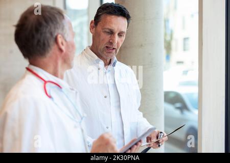 Doctors discussing over report in hospital Stock Photo