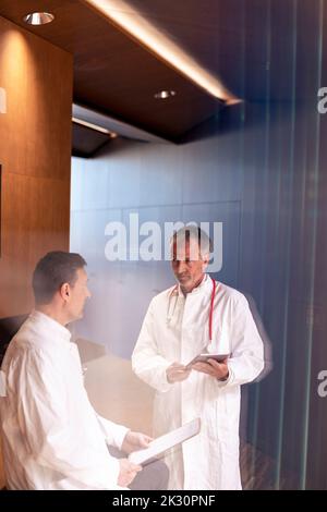 Healthcare workers discussing over report document in hospital Stock Photo
