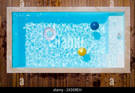 Inflatable ring and ball floating in swimming pool Stock Photo