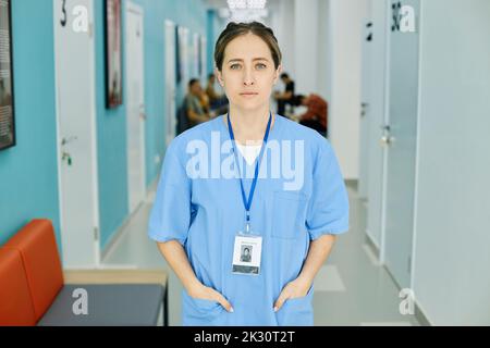 Nurse wearing scrubs standing in hospital corridor Stock Photo