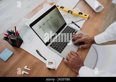 Hands of architect using laptop at desk in office Stock Photo