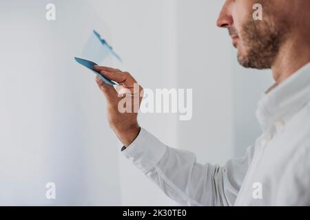 Hand of businessman sticking adhesive note on glass Stock Photo