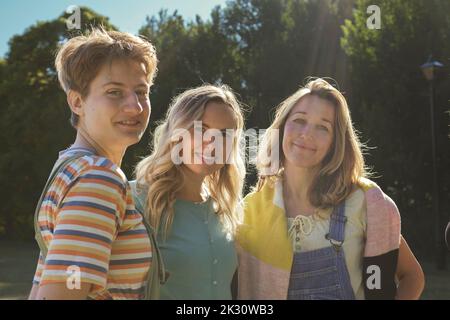 Smiling non-binary person with friends standing at park Stock Photo