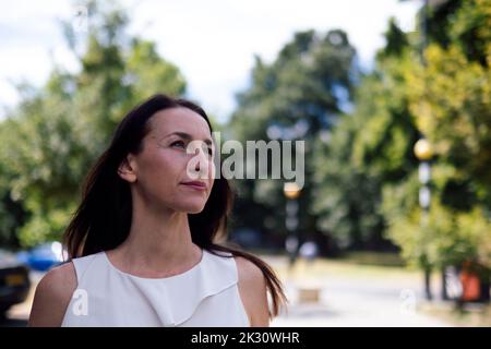 Smiling mature woman with long hair at park Stock Photo