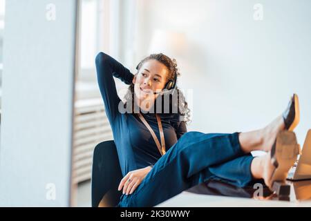 Young customer service representative talking through headset at office Stock Photo