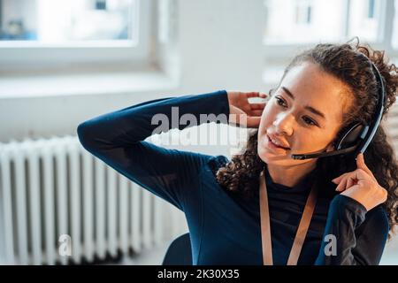 Young customer service representative wearing headset in office Stock Photo