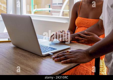 Hands of man using laptop by pregnant woman at home Stock Photo