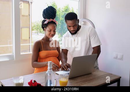 Multiracial couple using laptop on table at home Stock Photo