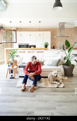 Man spending leisure time with dog at home Stock Photo