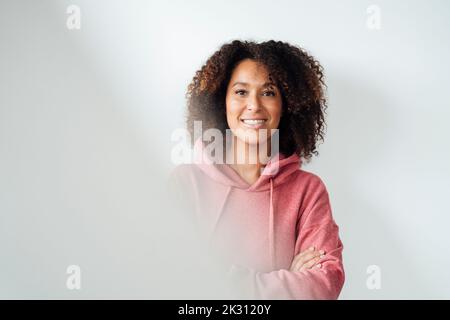 Smiling mature woman in front of white wall Stock Photo