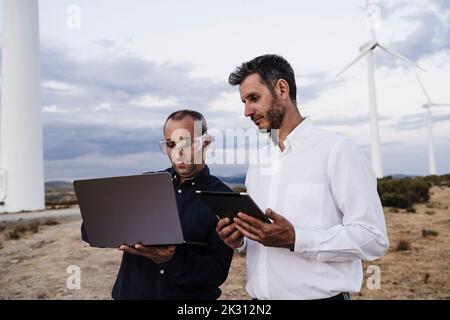 Engineers working on wireless technologies at wind farm Stock Photo