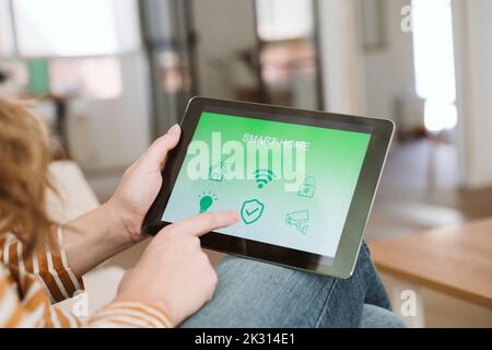 Close-up of woman using digital tablet with smart home app Stock Photo