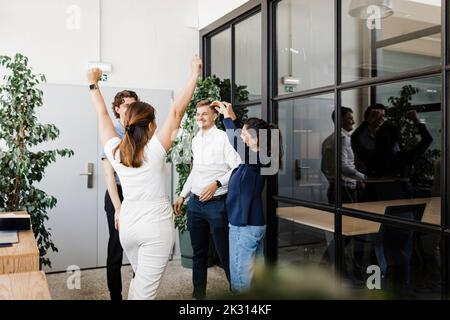 Cheerful business colleagues standing together in modern office Stock Photo