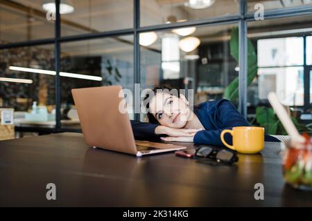 Smiling businesswoman day dreaming in office Stock Photo